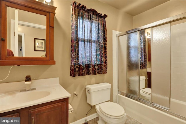 full bathroom featuring combined bath / shower with glass door, vanity, and toilet