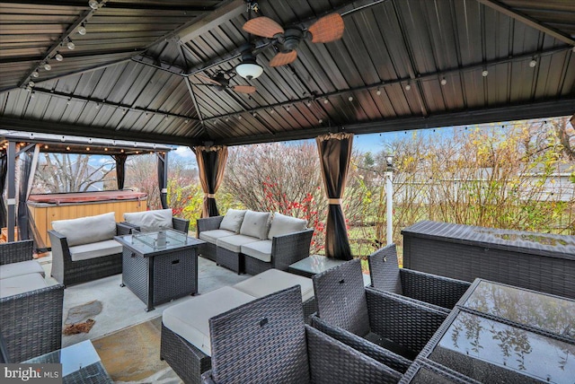 view of patio / terrace featuring a gazebo, an outdoor living space, a hot tub, and ceiling fan