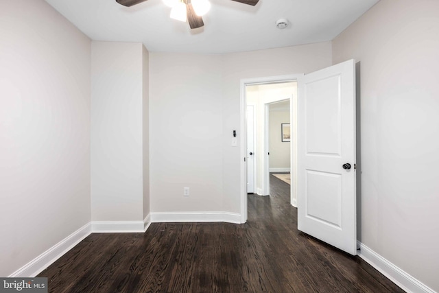 empty room featuring dark hardwood / wood-style flooring and ceiling fan