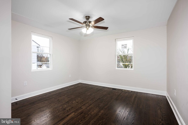 unfurnished room with ceiling fan and dark wood-type flooring