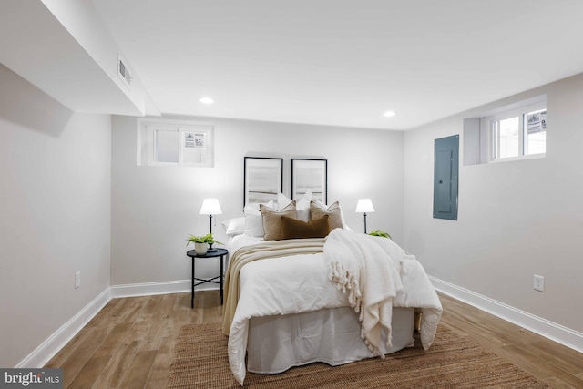 bedroom featuring electric panel and light hardwood / wood-style flooring