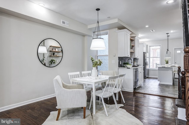 dining area featuring sink and dark wood-type flooring