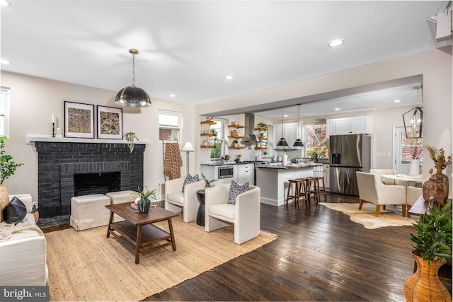 living room featuring light wood-type flooring and a brick fireplace