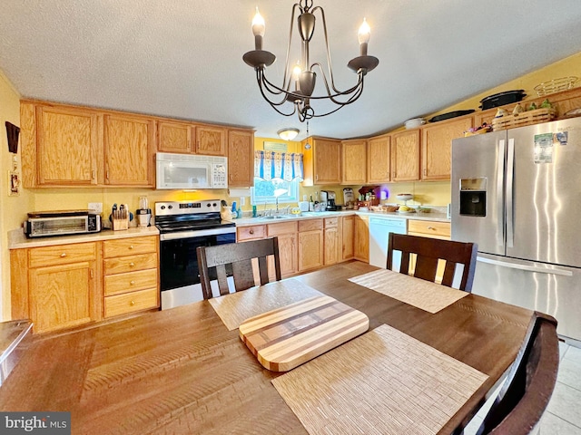 kitchen with an inviting chandelier, hanging light fixtures, vaulted ceiling, a textured ceiling, and appliances with stainless steel finishes