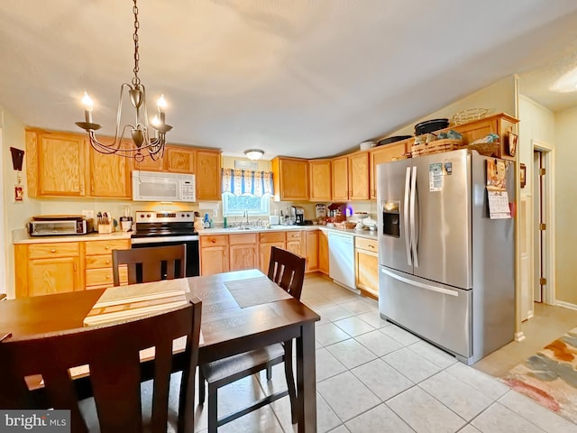 kitchen with sink, light brown cabinets, hanging light fixtures, an inviting chandelier, and appliances with stainless steel finishes