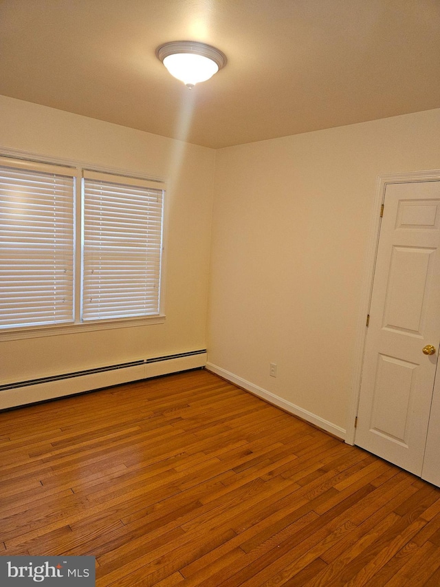 empty room featuring light hardwood / wood-style floors and baseboard heating