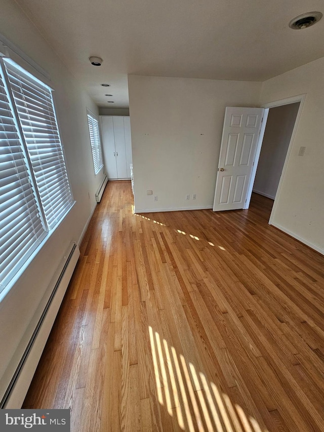 spare room featuring light hardwood / wood-style floors and a baseboard heating unit