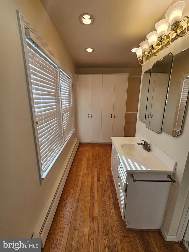 bathroom with baseboard heating, vanity, and hardwood / wood-style flooring