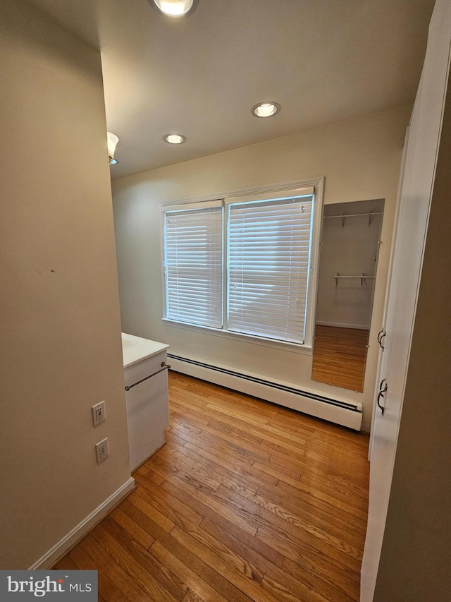 interior space featuring wood-type flooring and a baseboard radiator