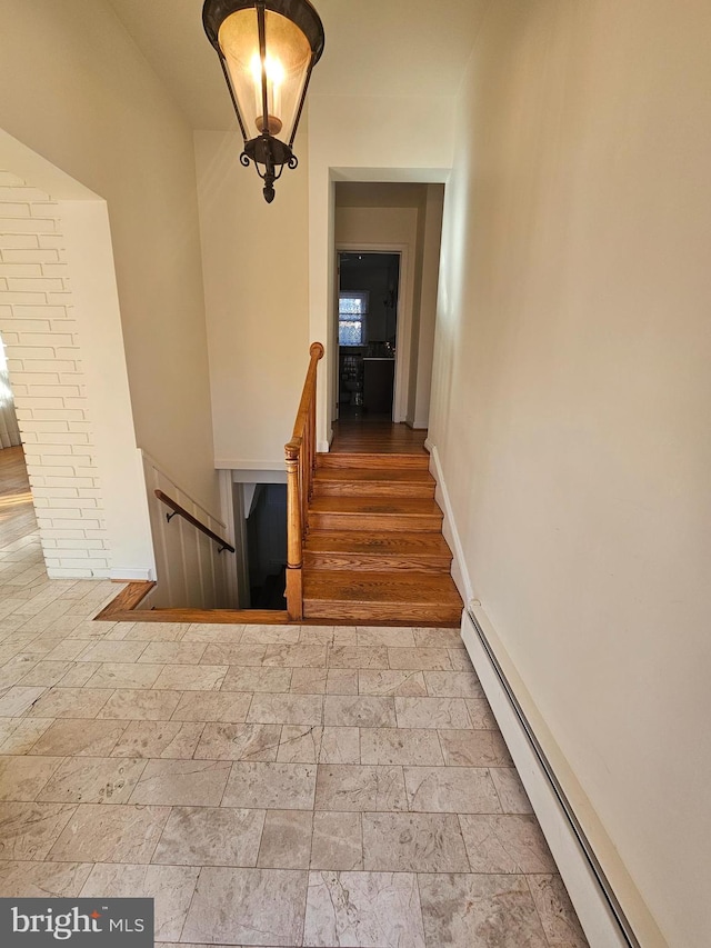 stairs with hardwood / wood-style flooring and a baseboard radiator