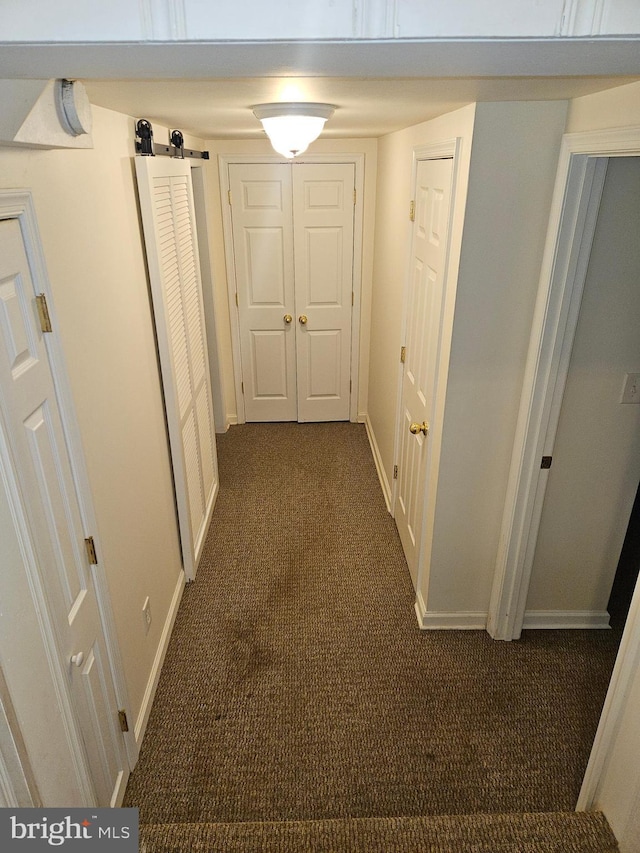 hall featuring dark carpet