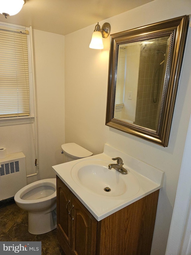 bathroom with vanity, toilet, and radiator heating unit