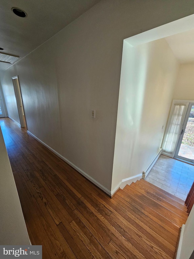 hallway with dark hardwood / wood-style flooring and vaulted ceiling