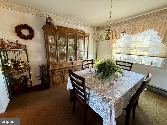 carpeted dining area featuring a chandelier