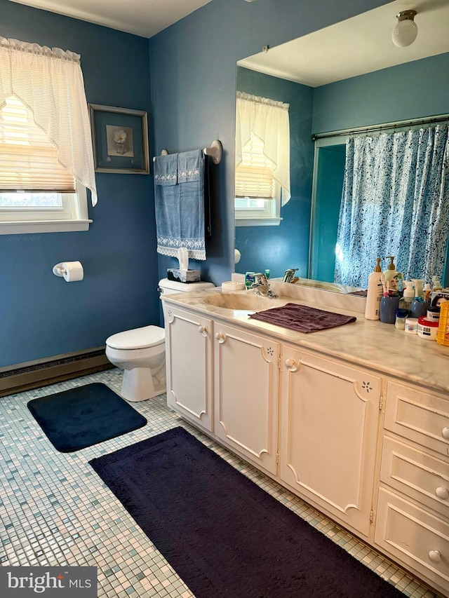 bathroom featuring vanity, a baseboard radiator, toilet, and a wealth of natural light