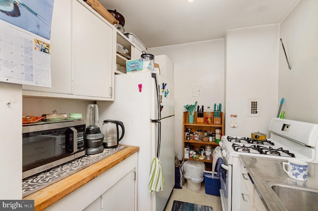 kitchen featuring white cabinetry and white appliances