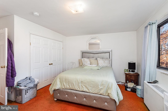 carpeted bedroom featuring a closet and radiator heating unit