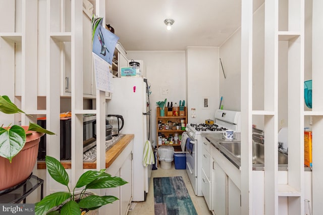 kitchen featuring white appliances, white cabinetry, and sink