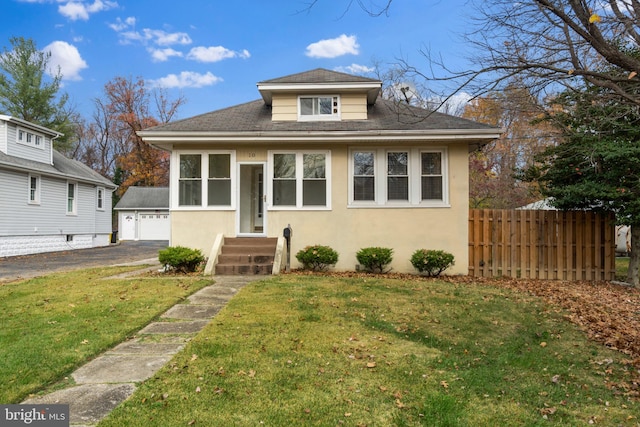 bungalow-style home featuring an outdoor structure and a front yard