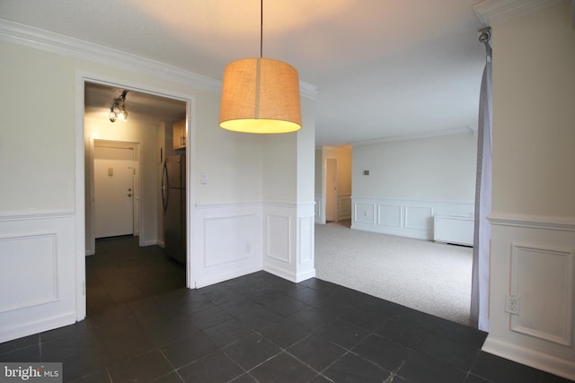 unfurnished dining area with dark carpet and ornamental molding