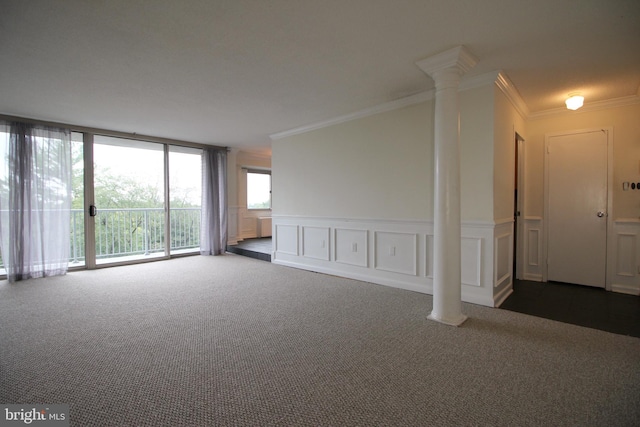 empty room featuring dark colored carpet, ornate columns, and ornamental molding