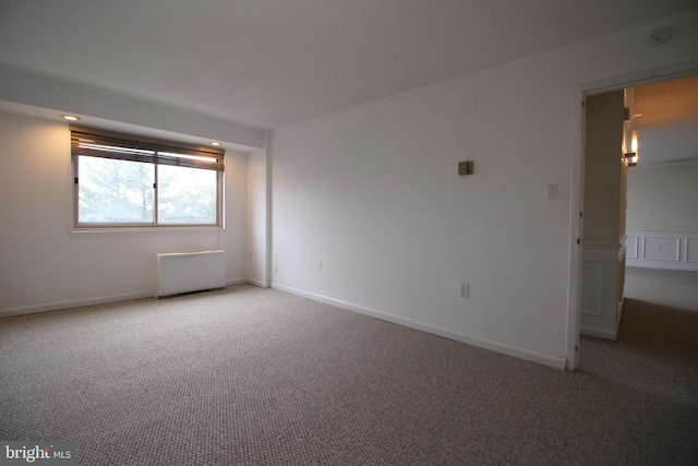 empty room with carpet and radiator heating unit