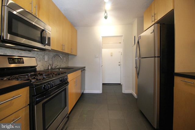 kitchen with tasteful backsplash, stainless steel appliances, dark tile patterned floors, sink, and light brown cabinets