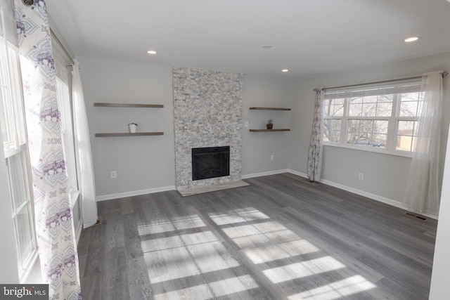 unfurnished living room featuring dark wood-type flooring and a fireplace