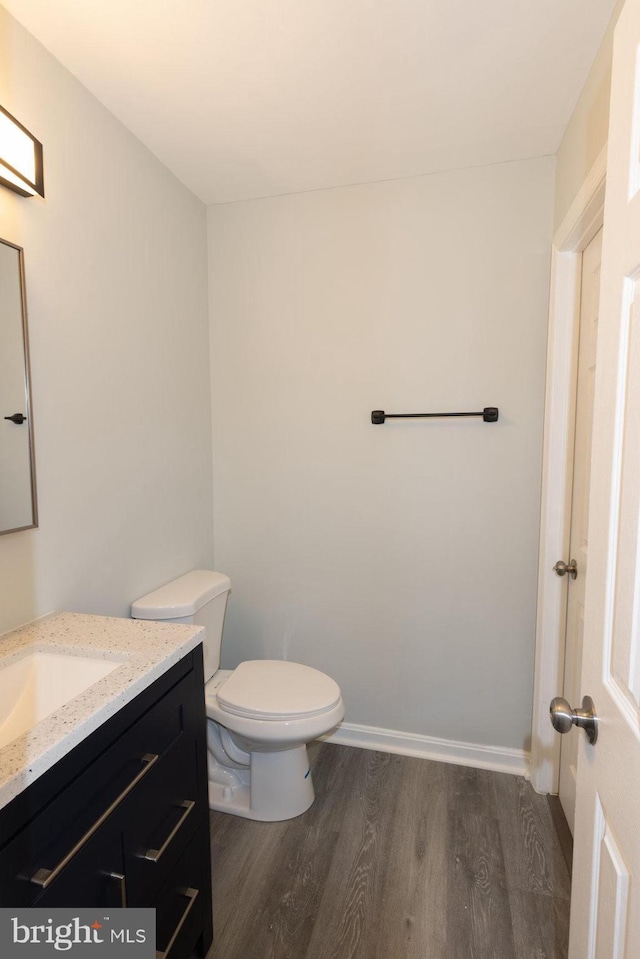 bathroom featuring vanity, hardwood / wood-style floors, and toilet