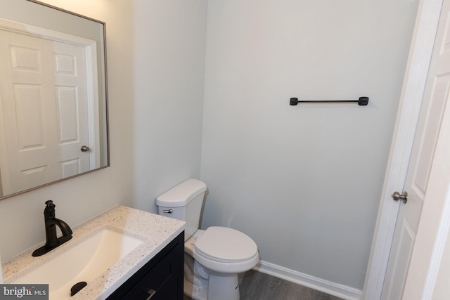 bathroom with vanity, hardwood / wood-style floors, and toilet