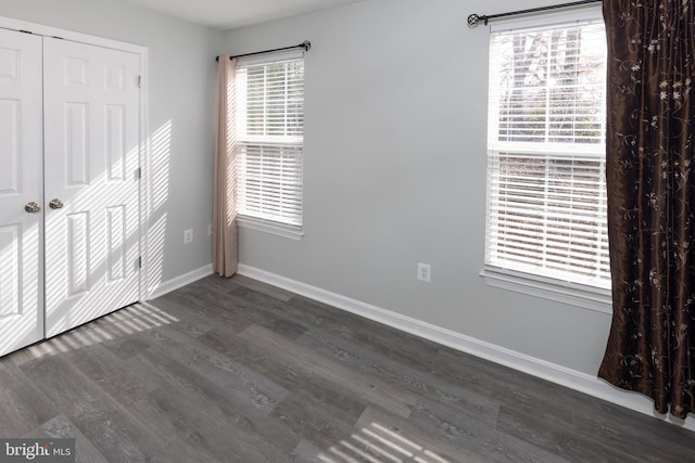 unfurnished bedroom featuring dark hardwood / wood-style floors and a closet