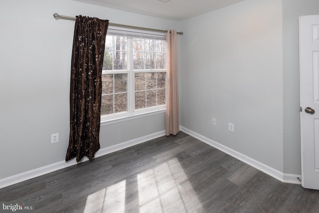 unfurnished room with dark hardwood / wood-style flooring