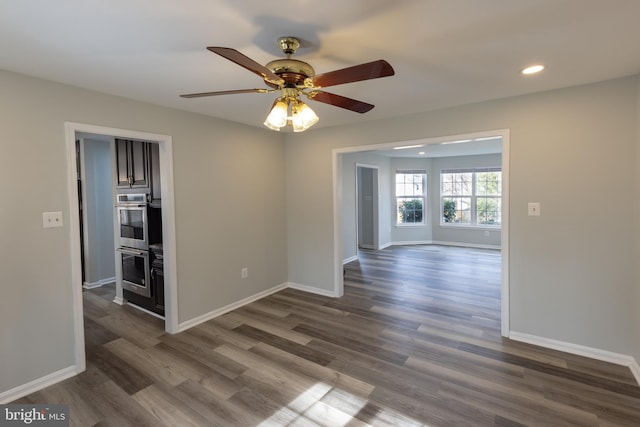 empty room featuring ceiling fan and dark hardwood / wood-style flooring