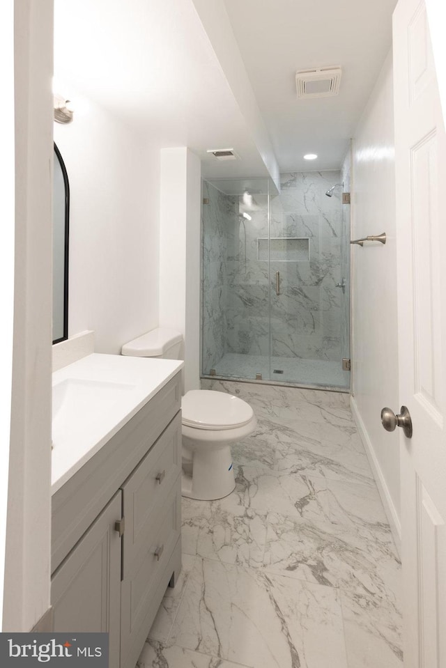 bathroom featuring vanity, a shower with shower door, and toilet