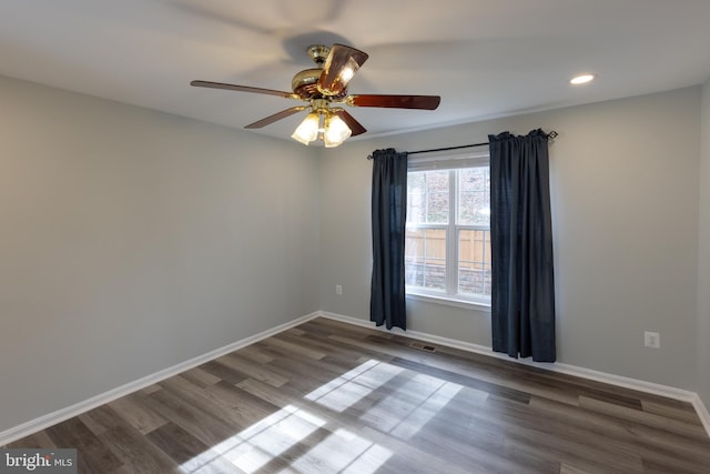 spare room with dark wood-type flooring and ceiling fan