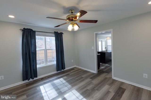 unfurnished room with sink, dark hardwood / wood-style floors, and ceiling fan