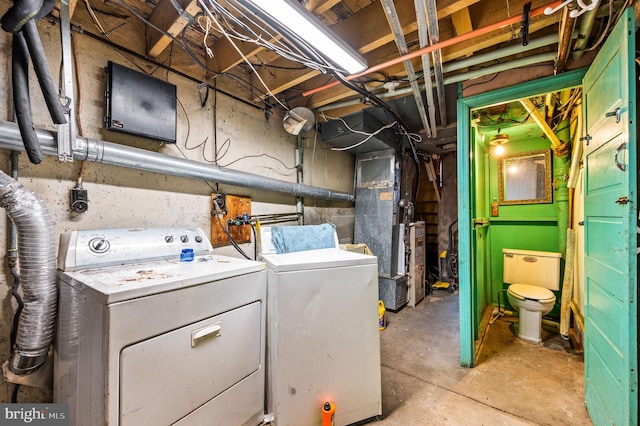 washroom with heating unit and washer and clothes dryer