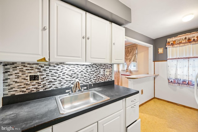 kitchen featuring backsplash, white cabinetry, and sink