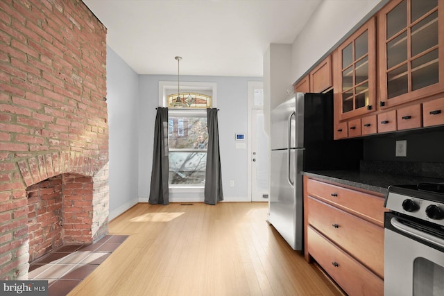 kitchen with light wood-type flooring, decorative light fixtures, and white range oven