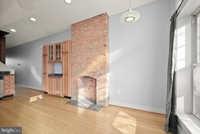 unfurnished living room with a fireplace and light hardwood / wood-style flooring