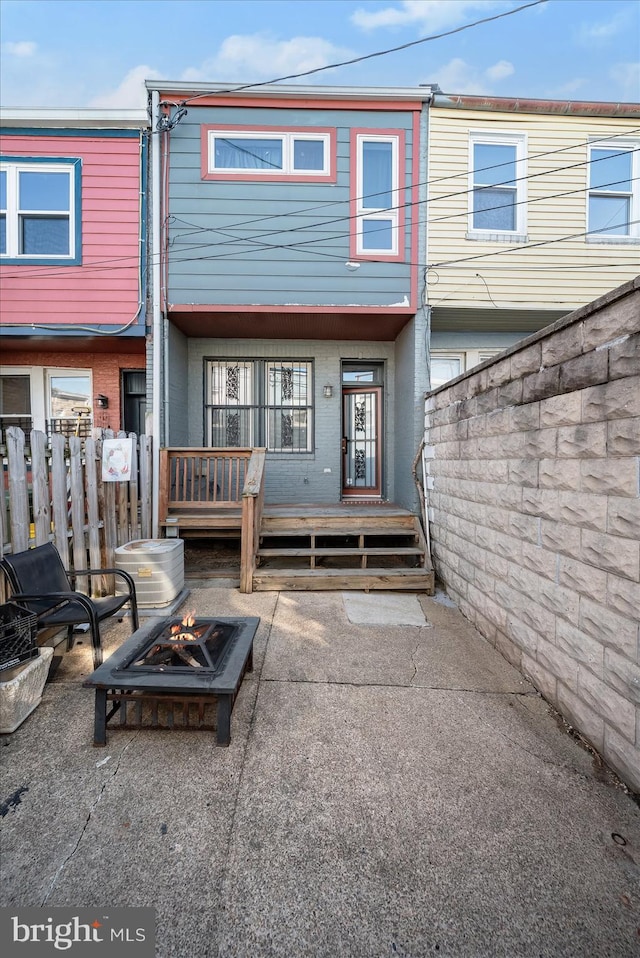 back of property with an outdoor fire pit and a patio area