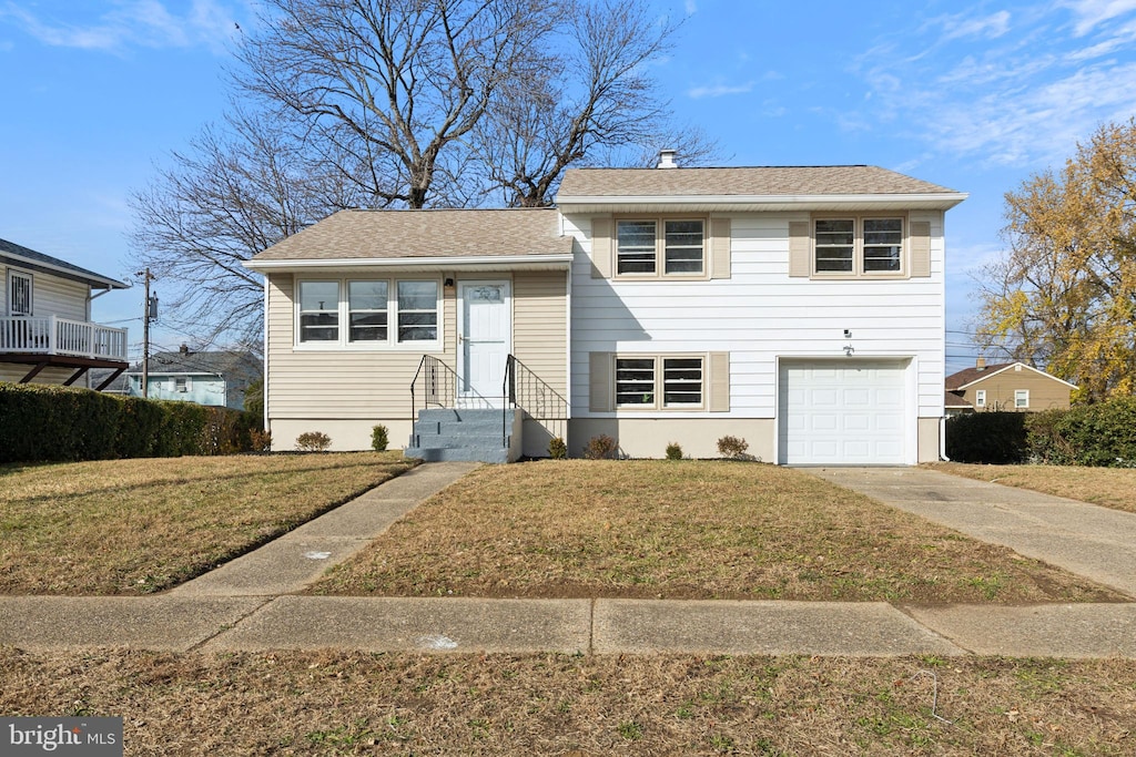 tri-level home featuring a garage and a front yard