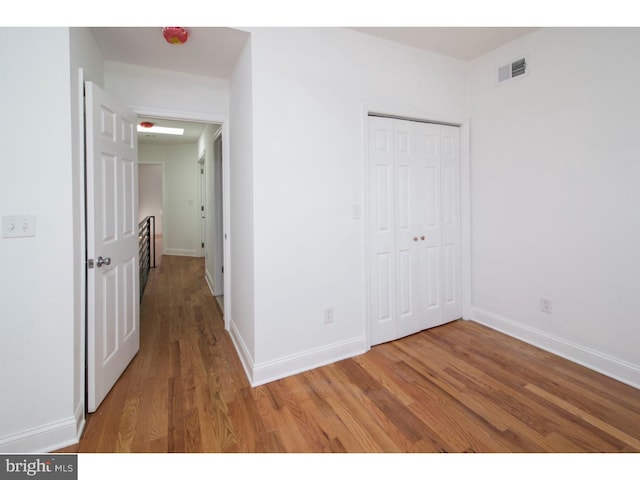 unfurnished bedroom featuring a closet and wood-type flooring