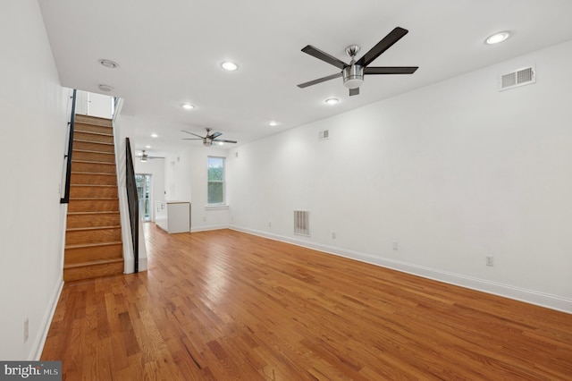 unfurnished living room featuring ceiling fan and light wood-type flooring