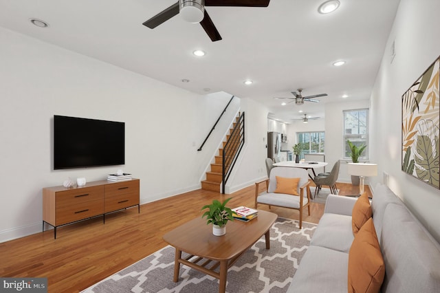 living room with light hardwood / wood-style flooring and ceiling fan