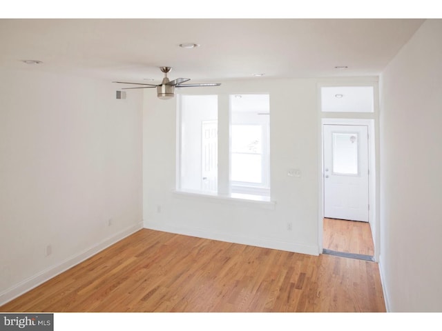 empty room with ceiling fan and light hardwood / wood-style flooring