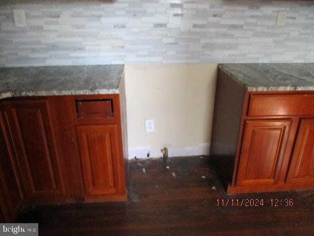 interior details featuring light stone counters and dark wood-type flooring