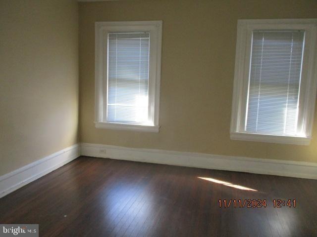 unfurnished room featuring dark wood-type flooring