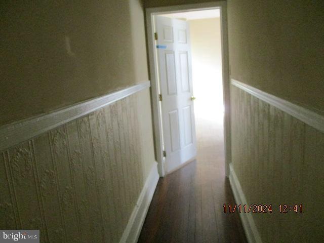 hall with hardwood / wood-style flooring and wooden walls