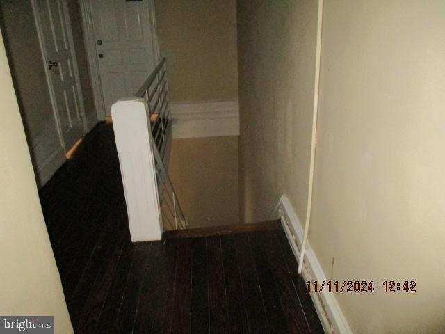 stairway featuring hardwood / wood-style floors and radiator heating unit